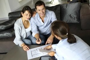Image of a professional property manager sitting down and talking to a couple